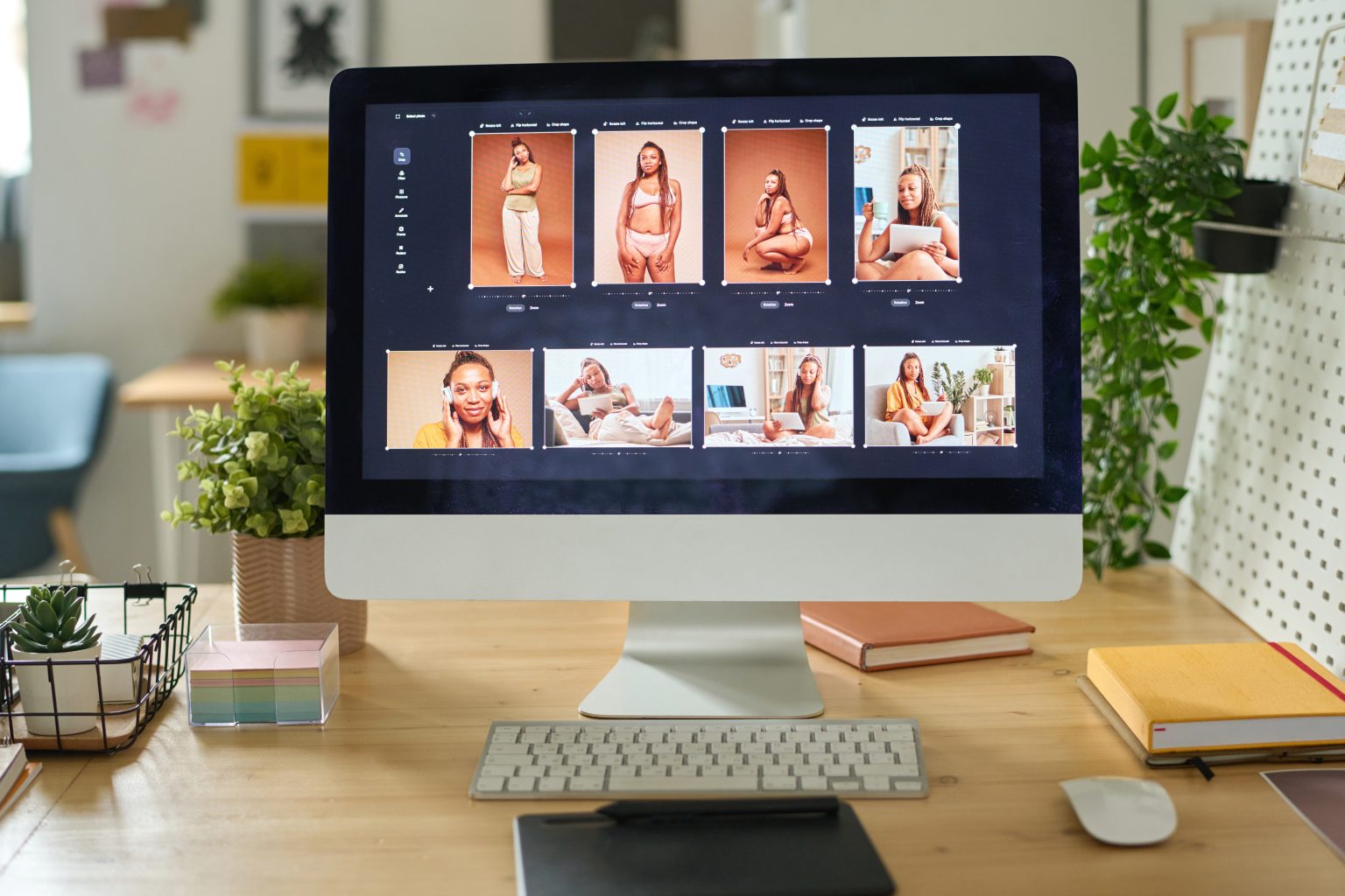 Horizontal image of desktop computer with photo editing software standing on desk at office